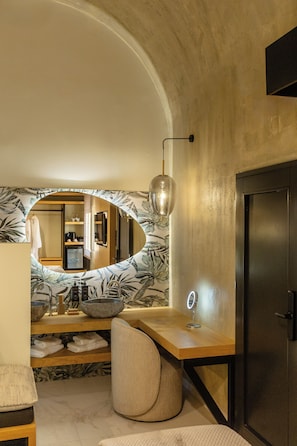 A bathroom with a large mirror, a wooden vanity, a bowl sink, and a towel rack.