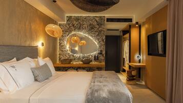 Una habitación de hotel moderna con una cama grande, un espejo redondo y un papel tapiz con motivos de hojas tropicales.