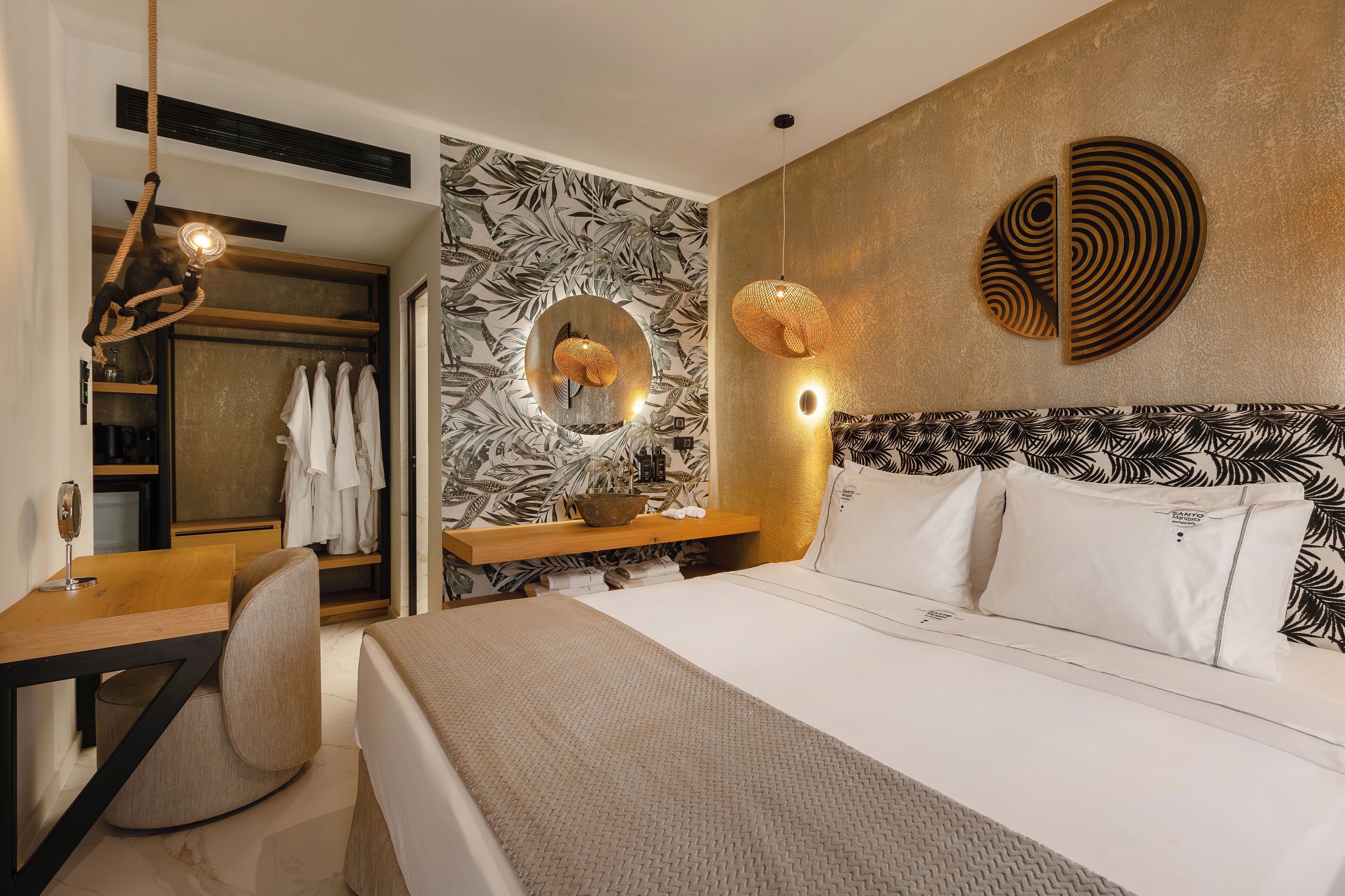 A modern hotel room with a bed, a desk, a chair, a wardrobe, and a bathroom.