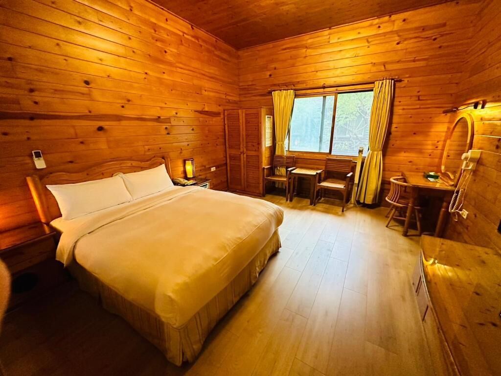 Una camera da letto in legno con un letto, una scrivania e una sedia.