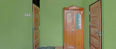 Una habitación con dos camas, un armario de madera y una puerta con espejo.