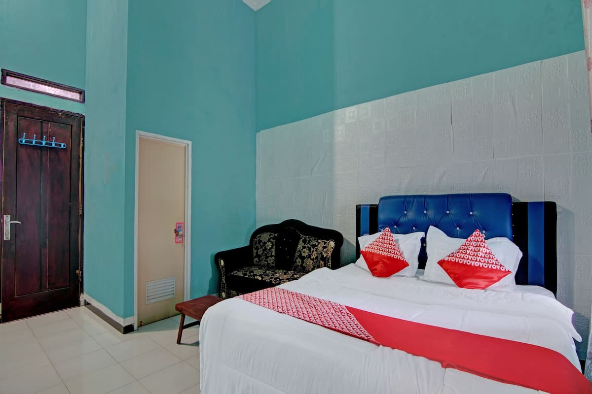 Une chambre à coucher avec un lit, une chaise, une porte et un mur orné d’un motif texturé.
