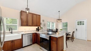 A kitchen with wooden cabinets, a stainless steel oven, a dishwasher, and a granite countertop.