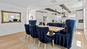 A dining area with a wooden table and dark blue upholstered chairs.