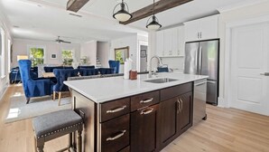 A modern kitchen with dark wooden cabinets, a white countertop, and stainless steel appliances.