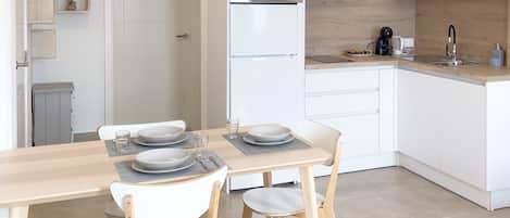 Uma cozinha moderna com armários brancos, micro-ondas embutido e uma pia.