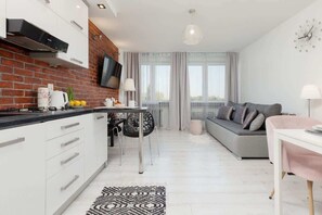 A modern apartment with a kitchen, dining area, and living room.