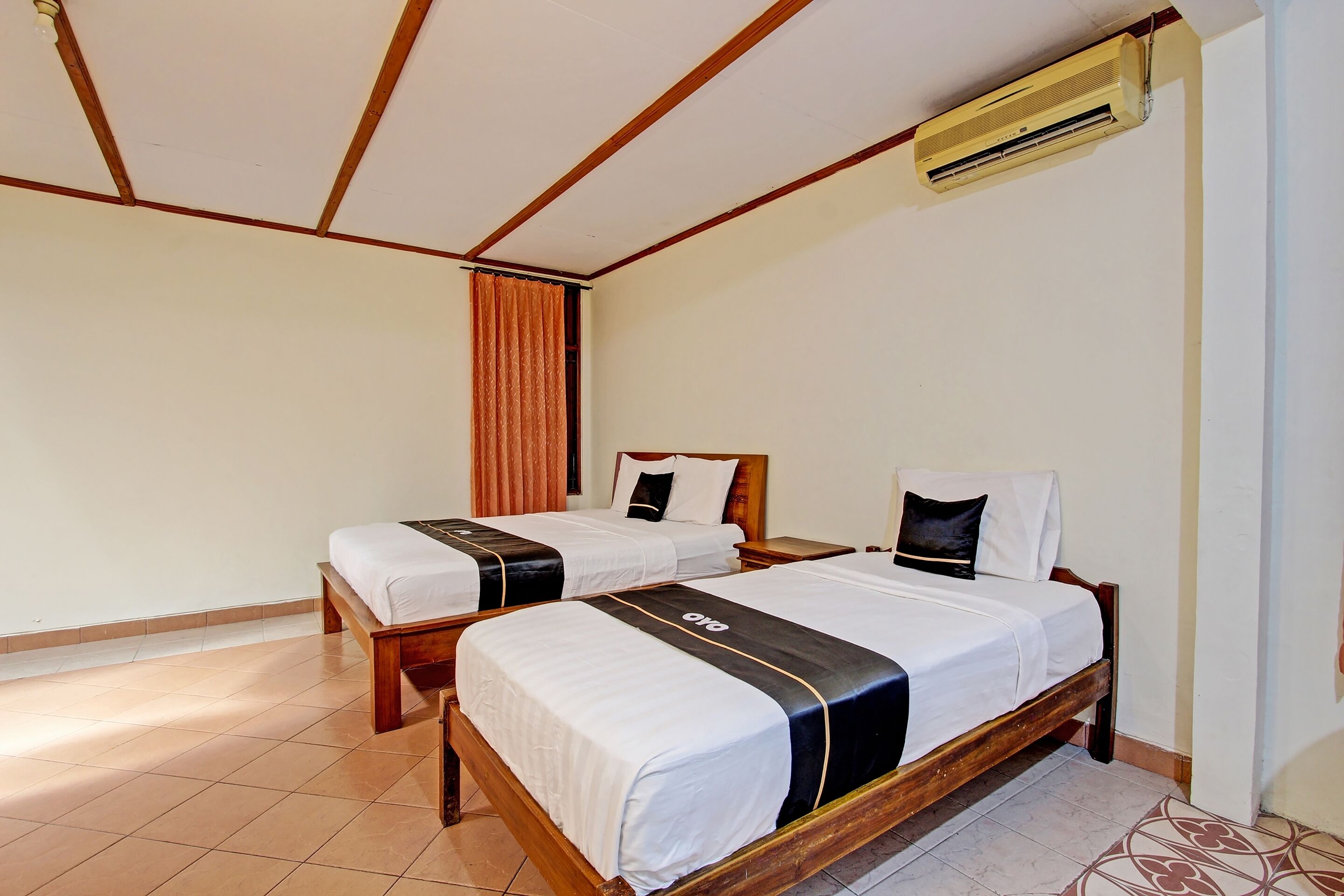 Ein Hotelzimmer mit zwei Holzbett und Klimaanlage und Deckenventilator.