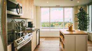 Een moderne keuken met een groot raam, een ingebouwde oven en een houten aanrecht.