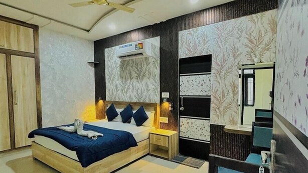A modern bedroom with a bed, bedside tables, a desk, and a mirror. - Hilltop Residency (Sawai Madhopur)