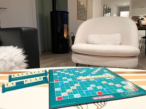 Una partita a Scrabble su un tavolo di legno, con il tabellone, le tessere e un portatessere.