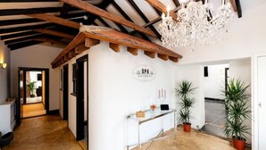 A spa reception area with a wooden ceiling, a chandelier, and potted plants. - Spa Retreat (relaxation centre) (Portsmouth)