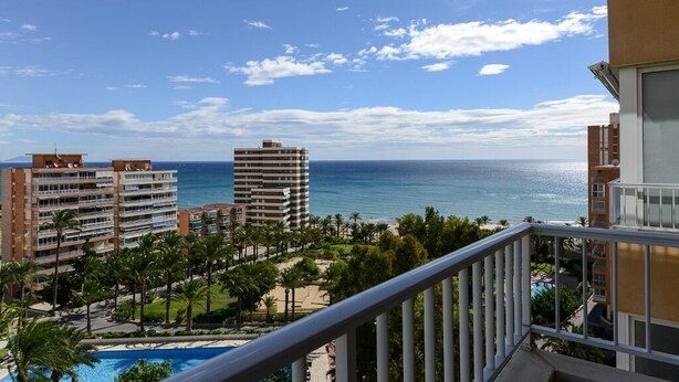 A hotel with a view of the ocean and a pool area.