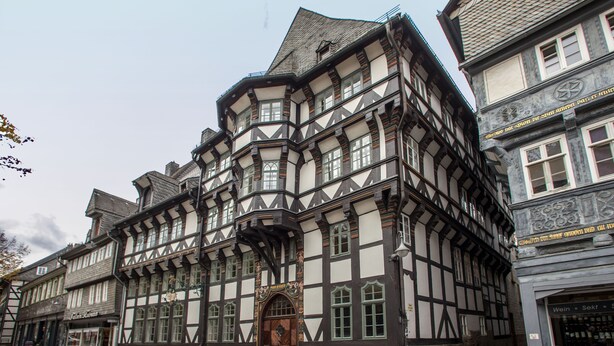 A traditional half-timbered building with a prominent wooden door and multiple windows. - Romantik Hotel Alte Münze (Goslar)