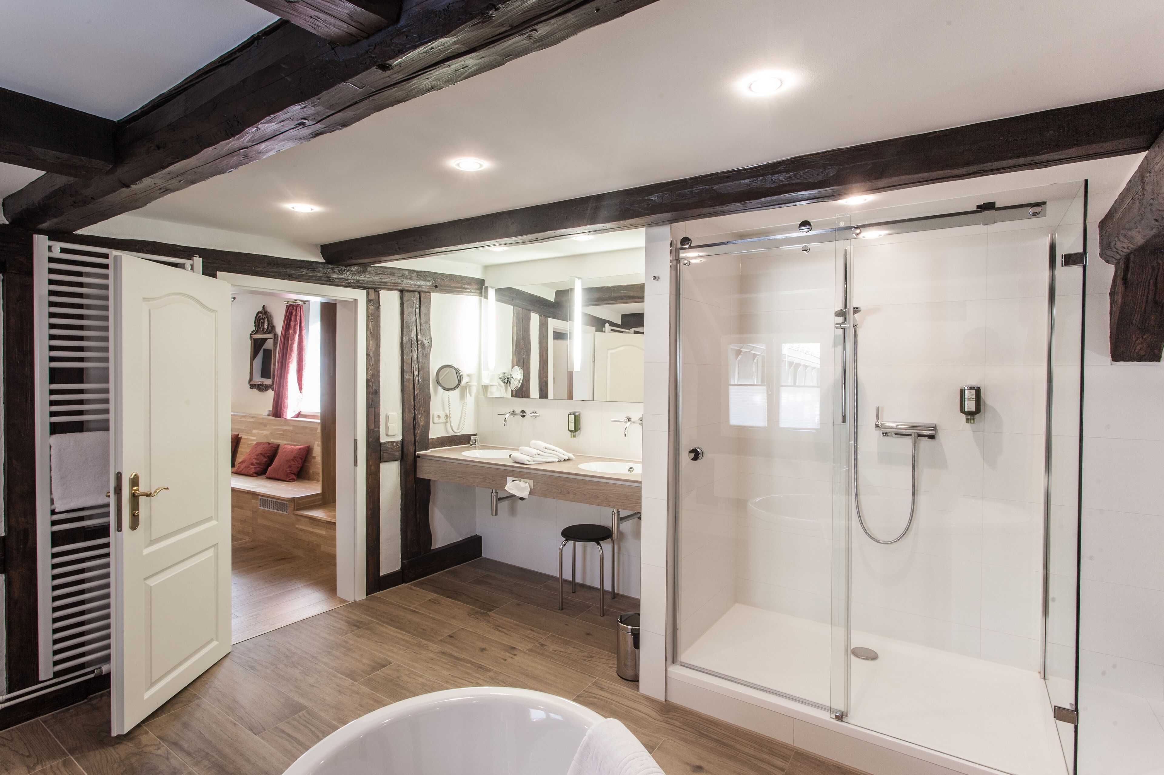 Un baño moderno con ducha envuelta en vidrio, bañera y tocador con espejo.