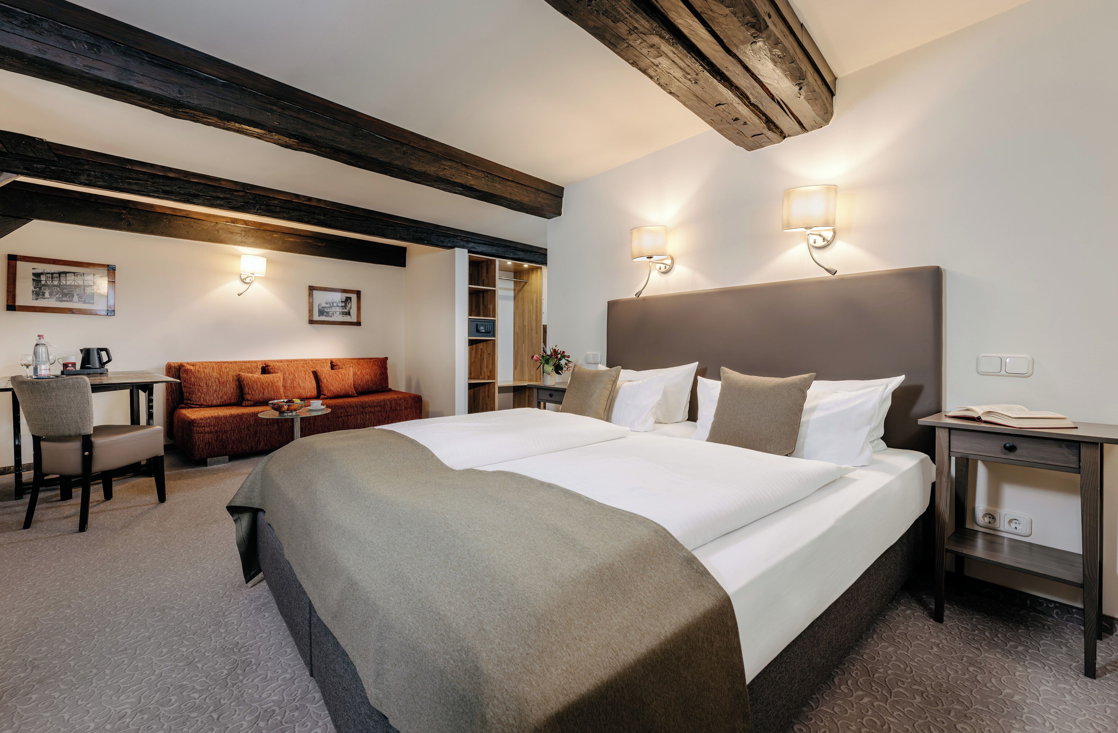 Ett hotellrum med en stor säng, en soffa, ett skrivbord och en garderob.