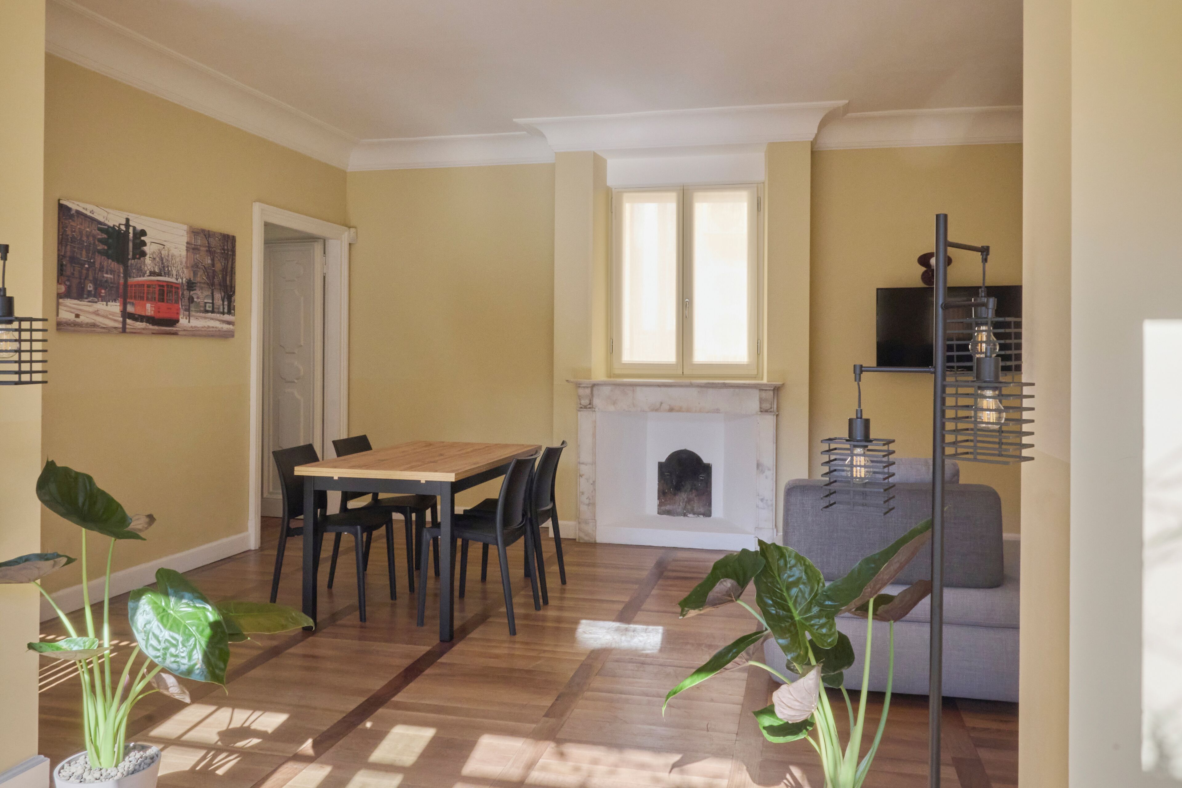 Un comedor con una mesa y sillas de madera, una chimenea y un sofá.