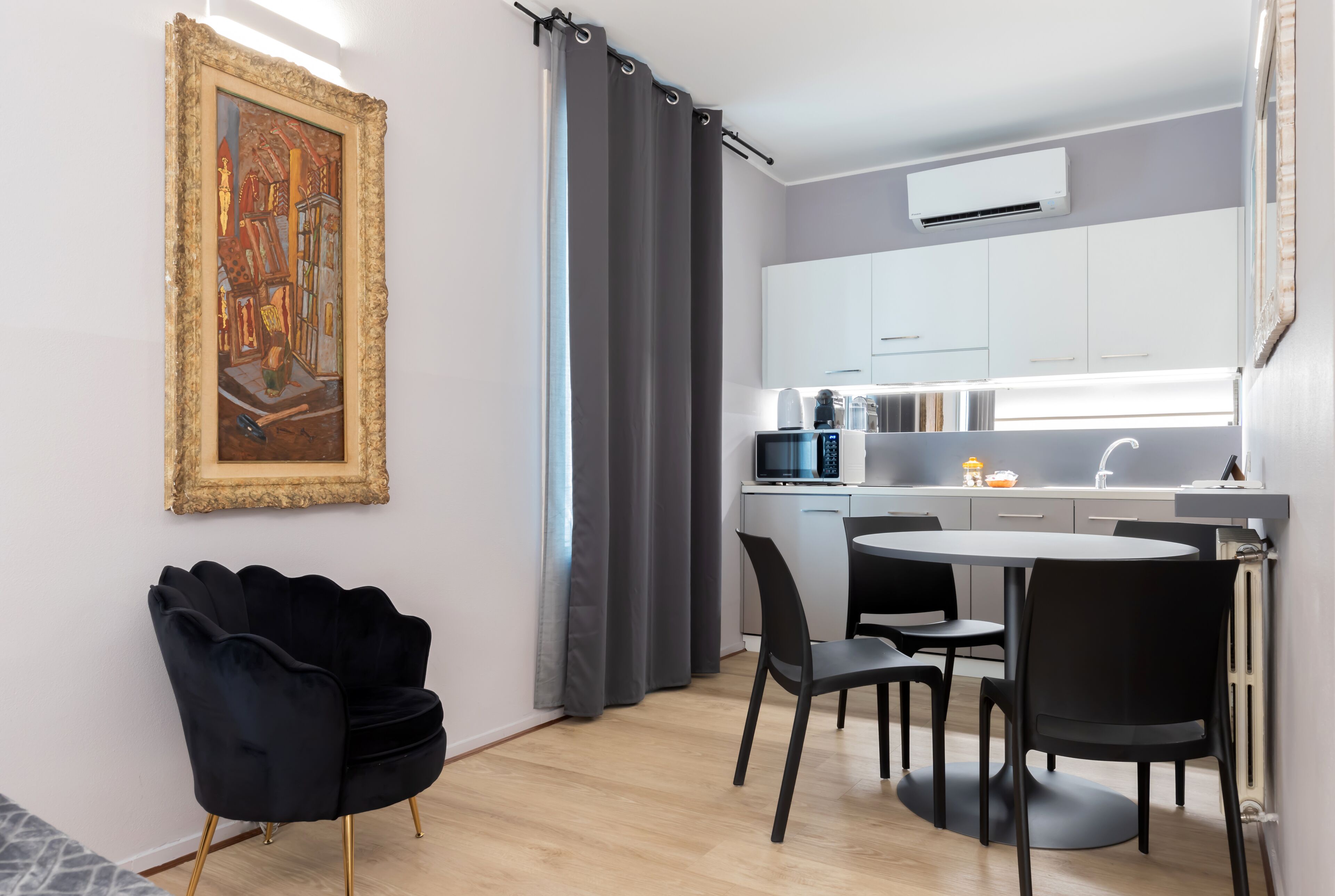 Une cuisine moderne avec des meubles blancs, une table à manger noire et des chaises.