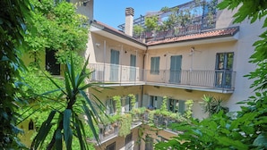 A multi-story building with balconies, greenery, and a clear sky. - Milan Retreats Duomo Carrobbio (Milan)