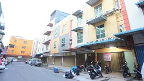 A multi-story building with a ground-level commercial space and upper residential units. - Hotel O City Room (Batam)