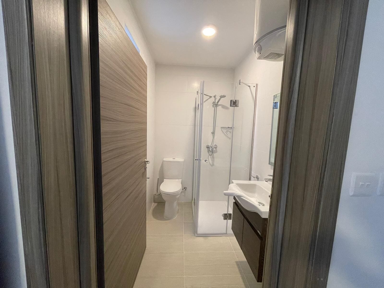 Une salle de bain moderne équipée de toilettes, d’une douche et d’un lavabo.