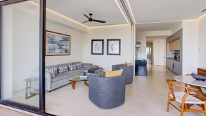 Una sala de estar moderna con un sofá, sillones y una mesa de comedor.