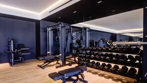 Un gimnasio moderno con diversos equipos de ejercicio, como mancuernas, bancos y máquinas de pesas.