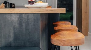 A modern kitchen with a wooden countertop, a built-in bench, and a window with a view of greenery. - Beautiful 2-bed Apartment in Oxford (Oxford)