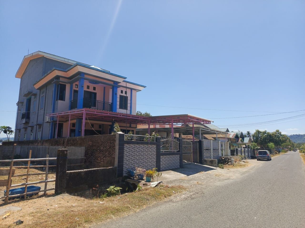 A two-story house with a balcony and a gated entrance.
