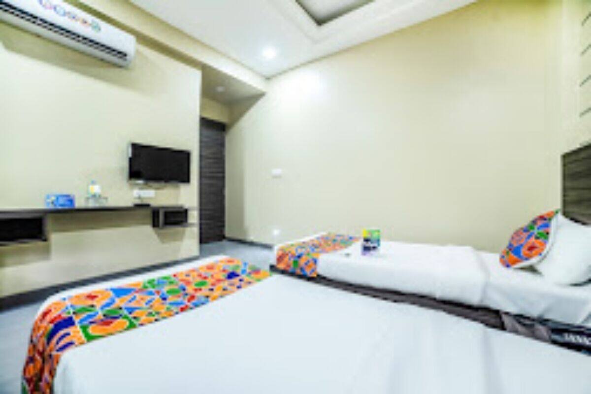 A hotel room with two beds, a television, and a minibar.