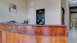 A wooden reception desk with a calendar and a notice board on the wall behind it. - Hotel O Wisma Pangestu SyariahNearTamanselera (Ujungtanjung)