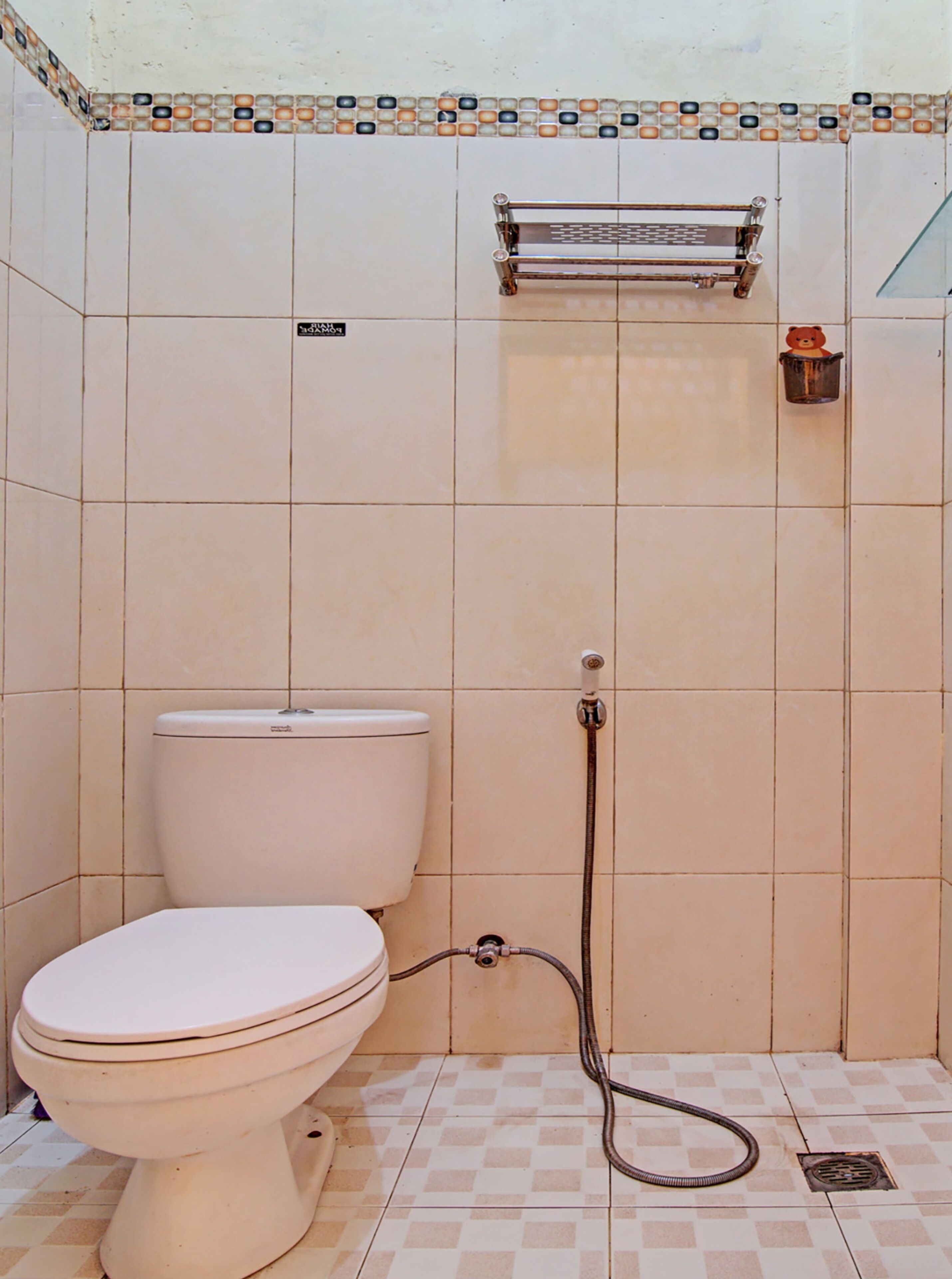 A bathroom with a toilet, a shower, and a tiled floor.