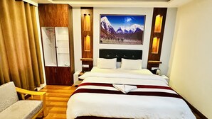 A hotel room with a large bed, a wooden wardrobe, a desk, and a chair. - Hotel Pyarij Taplejung (Taplejung)