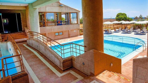 A hotel with a swimming pool, a sun deck, and a view of the ocean. - Ledras Beach Hotel (Rhodes)