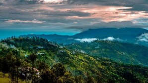 A mountainous landscape with terraced fields and scattered houses. - Hotel Pine & Dine Almora (Almora)