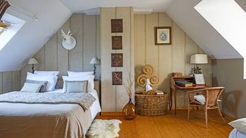 Quarto com cama grande, escrivaninha, cadeira, abajur, vaso e quadro na parede.