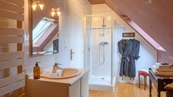 Un bagno moderno con una finestra a soffitto, una doccia a filo pavimento e un mobile lavabo con specchio.
