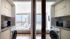 A modern kitchen with built-in appliances, a large window, and a view of the city. - Grand Sea View Retreat by Sea N' Rent (Tel Aviv)