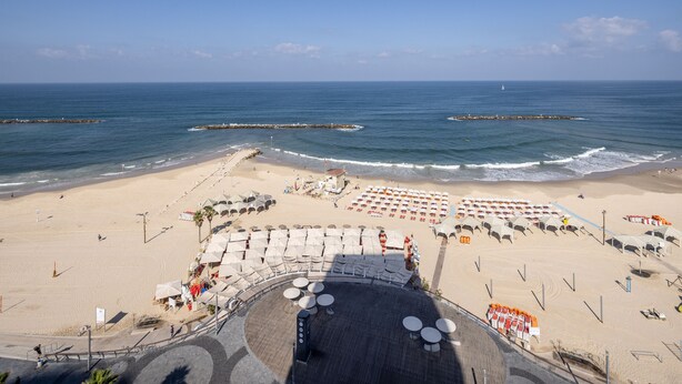 A beach with a stage, beach umbrellas, and lounge chairs. - Grand Sea View Retreat by Sea N' Rent (Tel Aviv)