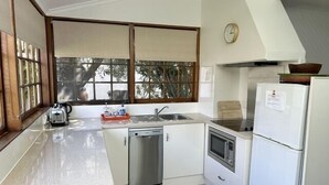 Een kleine keuken met een vaatwasser, een fornuis en een koelkast.