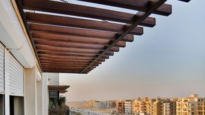 A balcony with a view of a cityscape, featuring modern buildings and a road. - Prime select Sodic Eastown New Cairo (New Cairo)