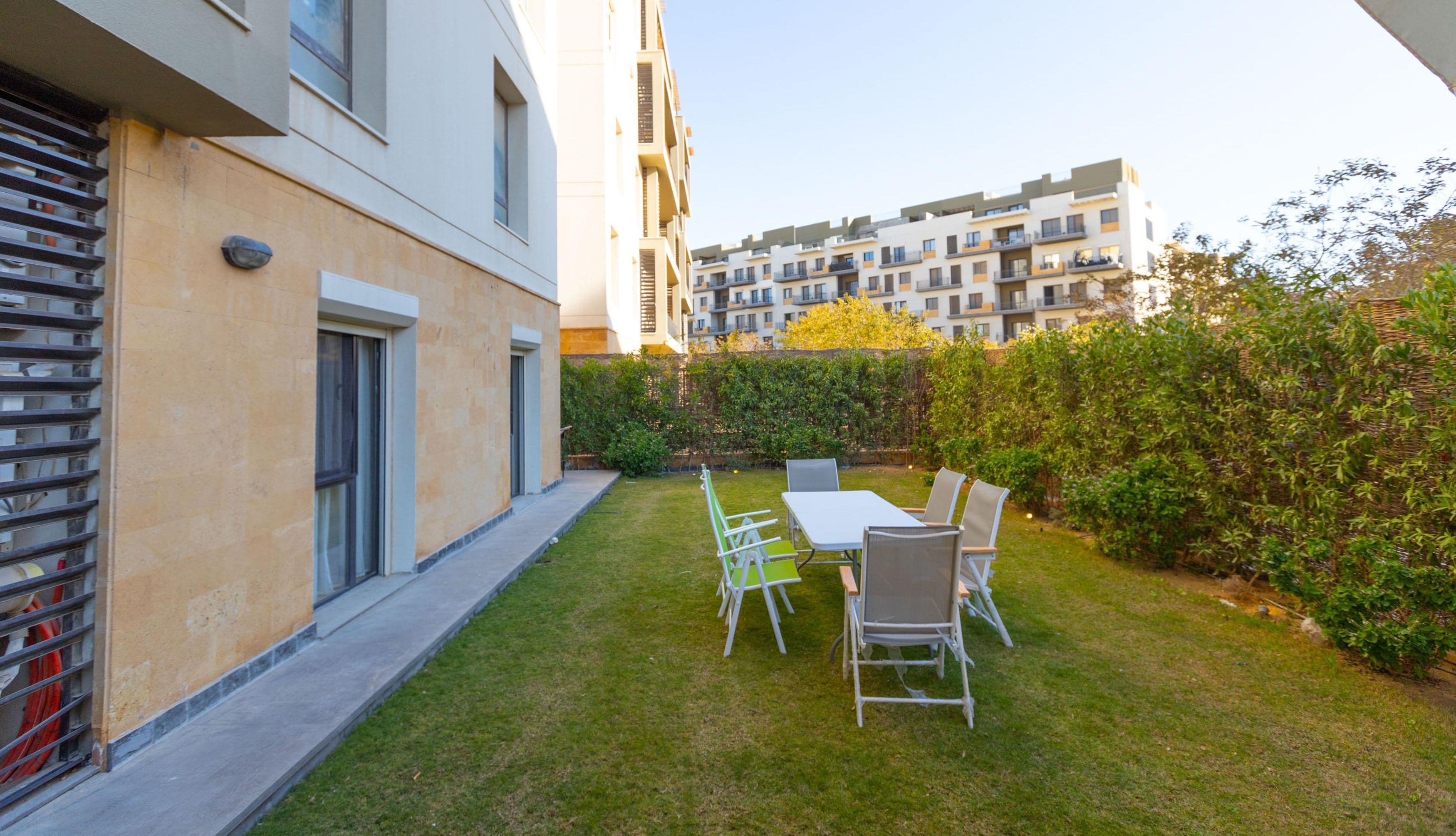 Un moderno edificio de apartamentos con un jardín bien cuidado y zona de estar al aire libre.