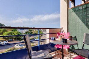 Enjoy a peaceful balcony with a clear view of the surrounding greenery, featuring a round table and two chairs.