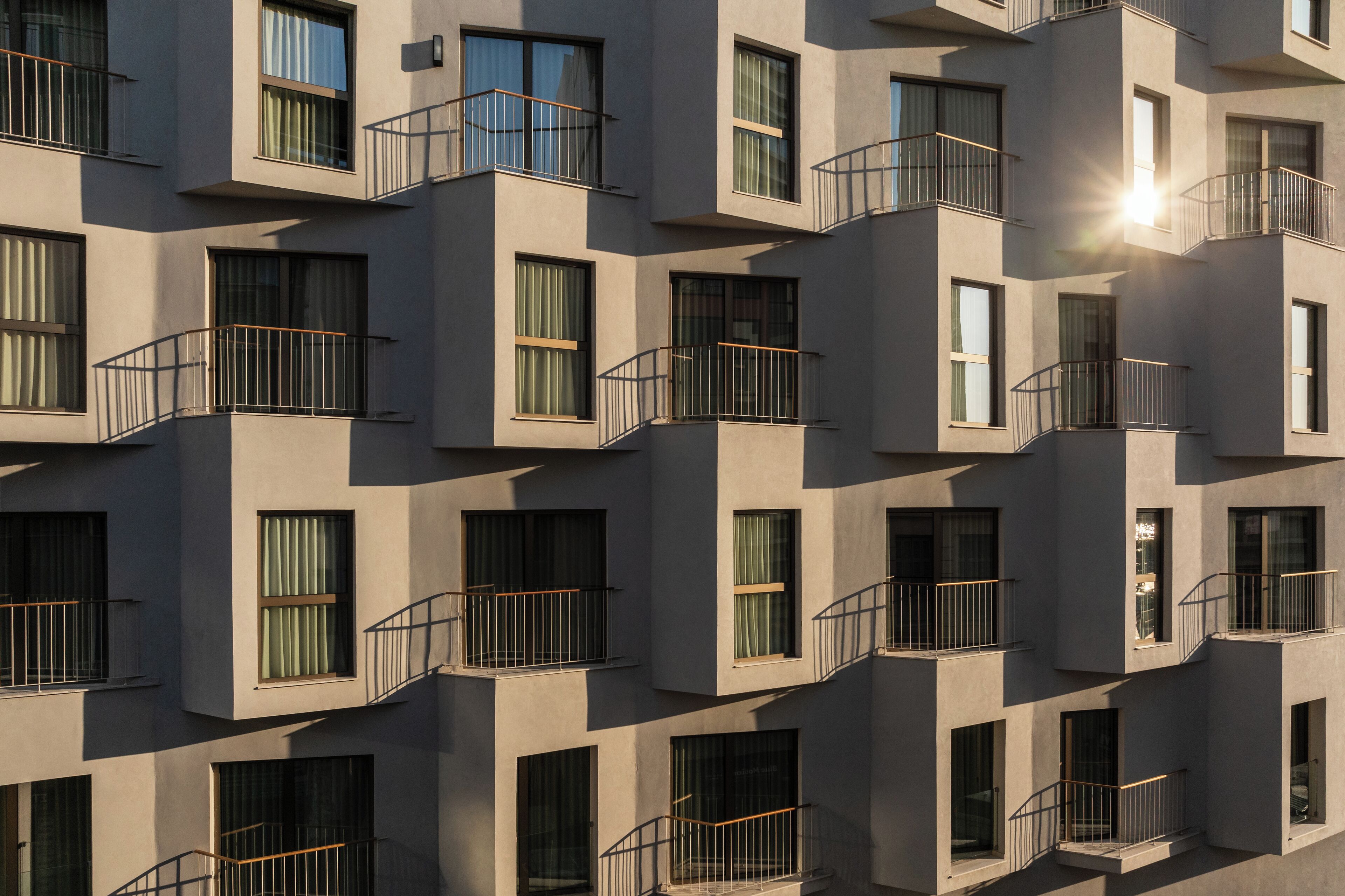 Un immeuble à plusieurs étages doté de balcons et de grandes fenêtres.