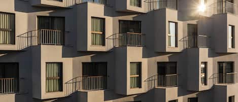 A multi-story building with balconies and large windows.