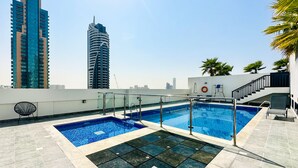 A rooftop swimming pool with a city skyline in the background. - Tanin-Beautiful and Modern Apartment with Huge Space (Dubai)