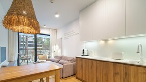 A modern kitchen with wooden cabinets, a wooden dining table, and a hanging light fixture. - RentPlanet - Shellter (Trzebiatow)