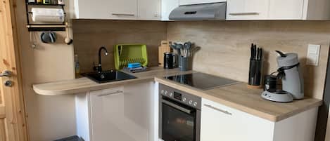 Een koelkast, een oven, een kookplaat, een koffiezetapparaat/waterkoker