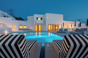 Una piscina al aire libre de temporada, sombrillas, tumbonas