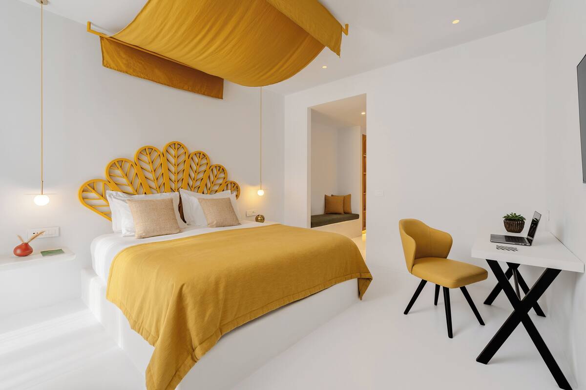 A modern bedroom with a bed, a desk, and a chair.